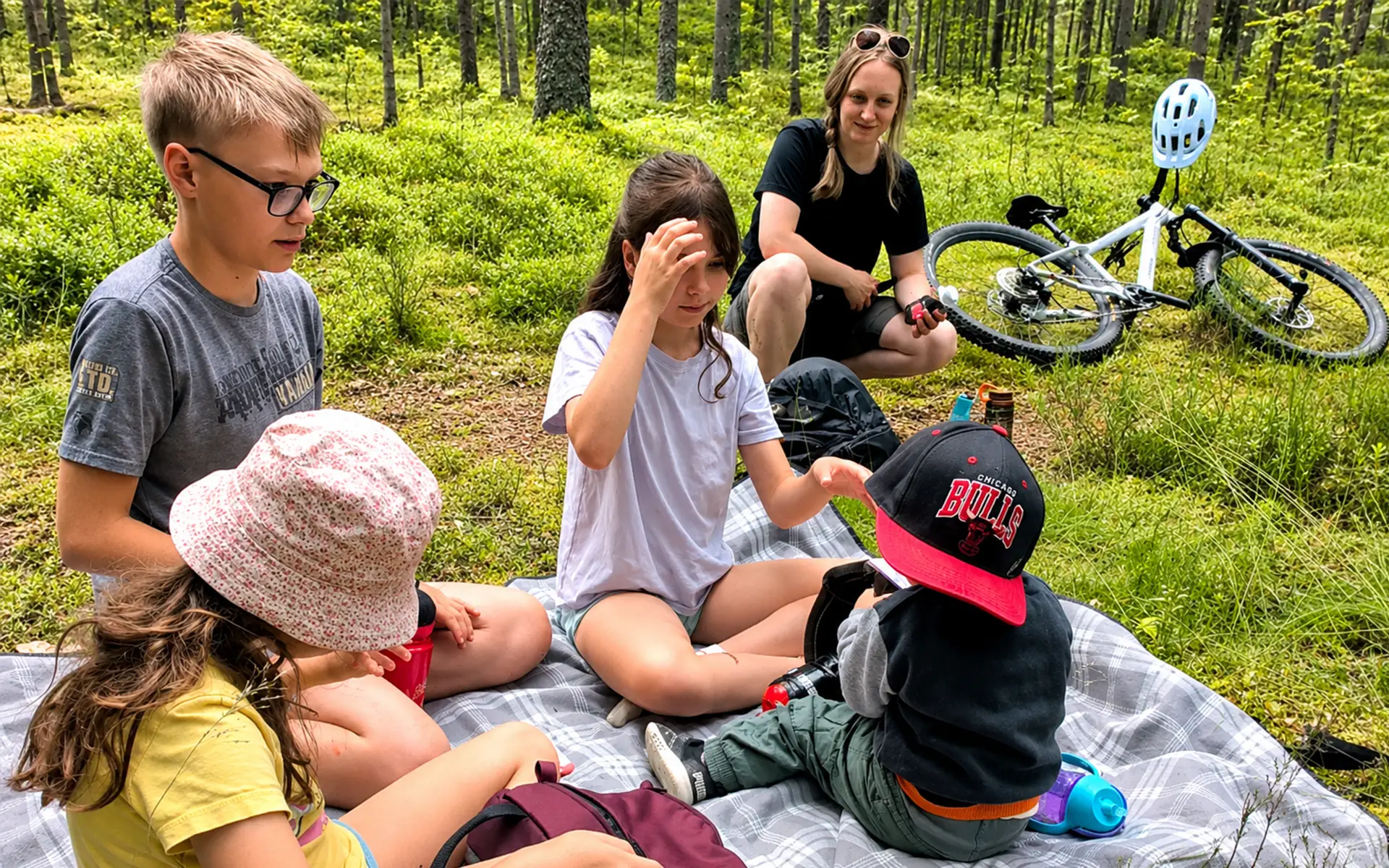 Perhe tauolla metsäpolun varrella