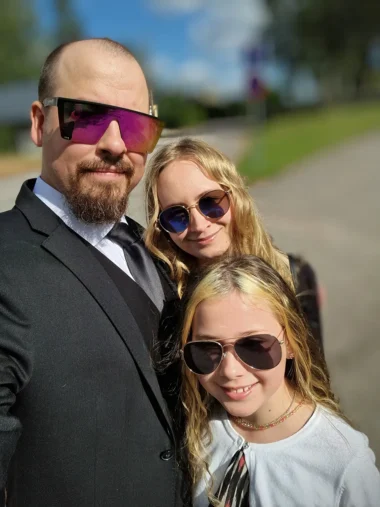 Meistä 1 Perhe poseeraa ulkona yhdessä.