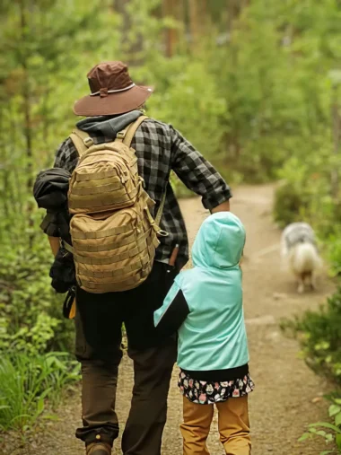 Meistä 24 isä ja tytär kävelyttämässä koiraa metsäpolulla