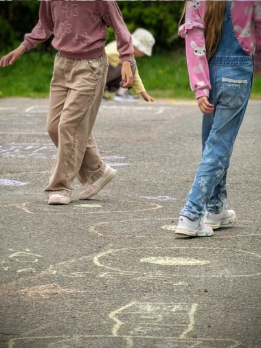Meistä 20 Lapset piirtävät liiduilla maahan.