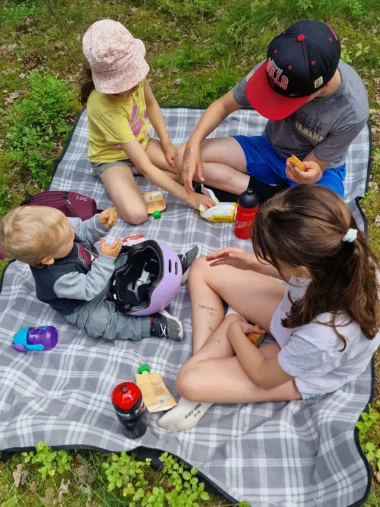 Eväiden jako menossa Lasten eväshetki picnic peitolla